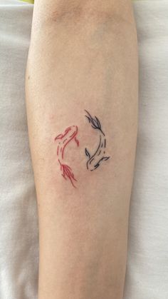 a person with a tattoo on their arm that has two koi fish in it