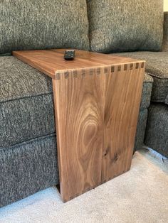 a wooden table sitting on top of a gray couch