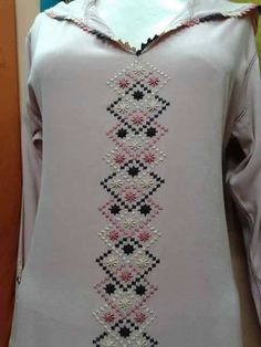 a woman's white top with black and pink flowers on it