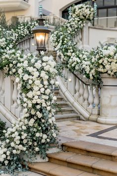 white flowers and greenery are growing on the stairs