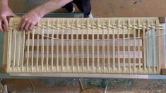 a man is working on a piece of furniture with wood and wicker weaves