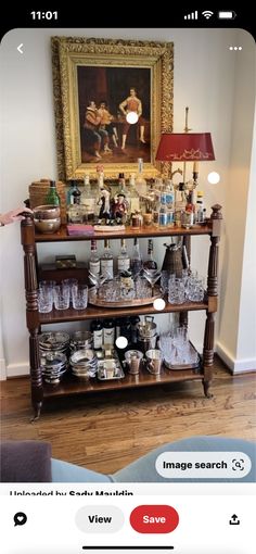 an old fashioned wooden shelf with many items on it and a painting in the background