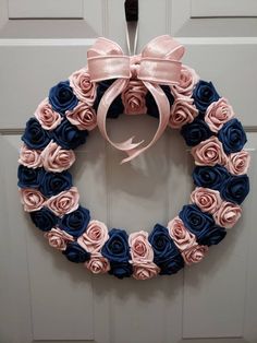 a wreath with pink and blue roses hanging on the front door