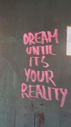graffiti on the side of a building reads, dream until it's your reality