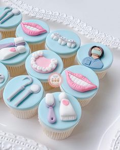 cupcakes decorated with blue and pink icing are arranged on a white platter