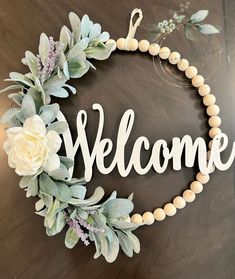 a sign that says welcome with flowers on it
