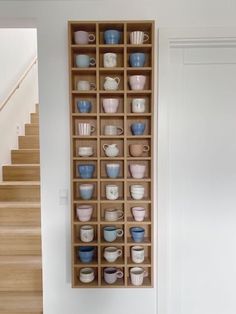 a wooden shelf filled with lots of cups