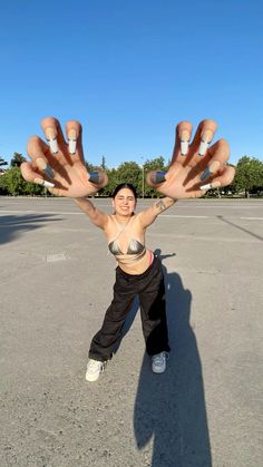 a woman standing in an empty parking lot holding her hands up