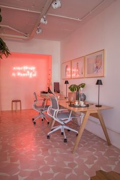 an office with pink walls and white chairs