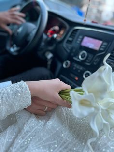 a person in a car with flowers on the dashboard