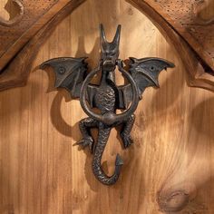a metal dragon mounted to the side of a wooden wall
