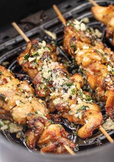 chicken skewers with parmesan cheese and herbs cooking on an outdoor grill