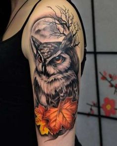 an owl and leaves tattoo on the arm