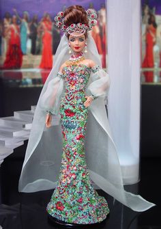 a barbie doll wearing a wedding dress with veil and flowers on it's head
