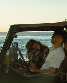 a man and woman in a jeep on the beach
