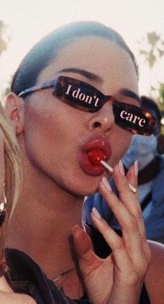 a woman wearing sunglasses with the words i don't care on them
