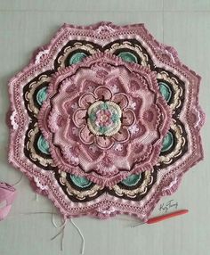 a crocheted doily is laying on the floor next to a knitting needle