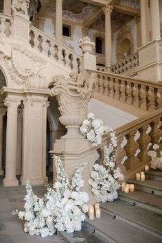 white flowers and candles are on the stairs