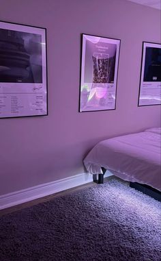 a bedroom with purple walls and pictures on the wall