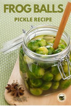 a glass jar filled with pickles on top of a wooden cutting board