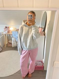 a woman taking a selfie in front of a mirror wearing pink and white pajamas