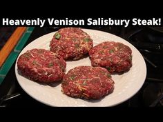 four hamburger patties on a white plate with the words heavenly venison salisbury steak