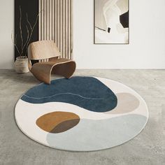 a living room with a chair and rug on the floor in front of a painting