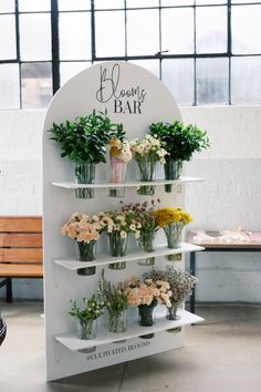 a flower shop display with flowers and greenery