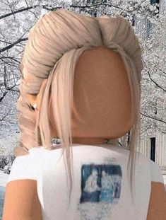 a woman with blonde hair wearing a white t - shirt in front of snow covered trees