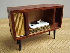 an old fashioned radio with a record player in it's cabinet on the floor