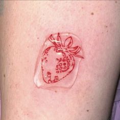 a close up of a person's arm with a strawberry on the back of it