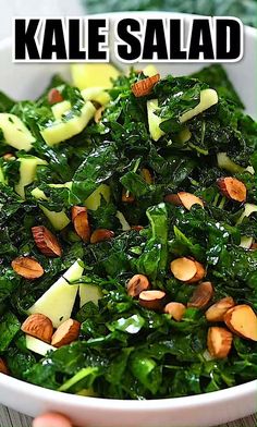 a white bowl filled with greens and nuts