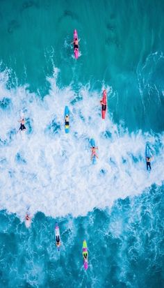 aerial view of surfers in the ocean with their surfboards and boogie boards, from above