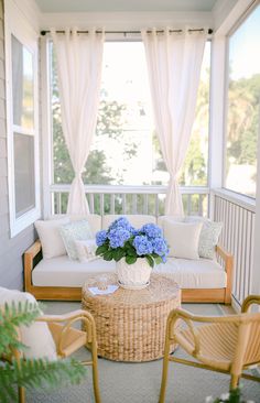 a living room with wicker furniture and blue flowers