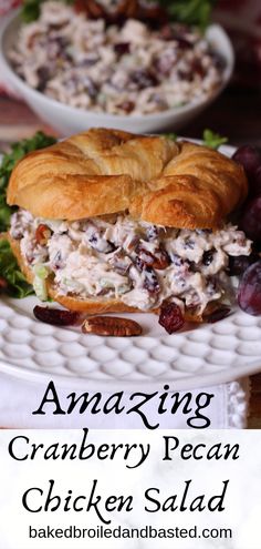 a cranberry pecan chicken salad sandwich on a white plate with grapes in the background