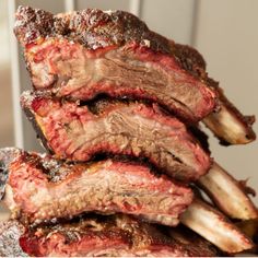 the ribs are piled on top of each other with text overlay that reads smoked beef back ribs