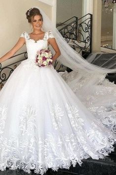 a woman in a wedding dress standing on stairs