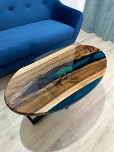 a surfboard shaped coffee table sitting on top of a hard wood floor next to a blue couch
