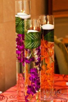 two tall vases filled with flowers and candles