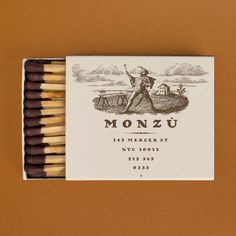 an unopened matchbox with two matches in it and the label for monzu