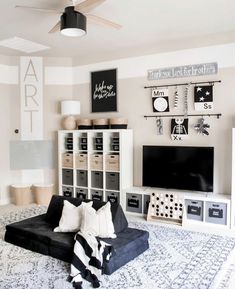 a living room with black and white decor on the walls, shelves, and a couch