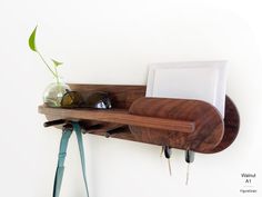there is a wooden shelf with sunglasses and a plant in it on the wall next to a pair of eyeglasses