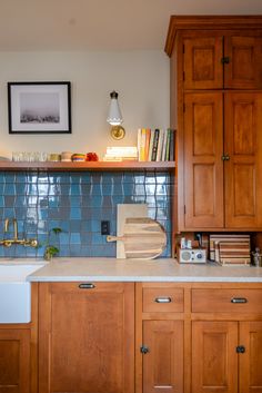 a kitchen with wooden cabinets and blue tile backsplashing on the counter top