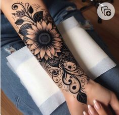 a woman's arm with a sunflower tattoo on it