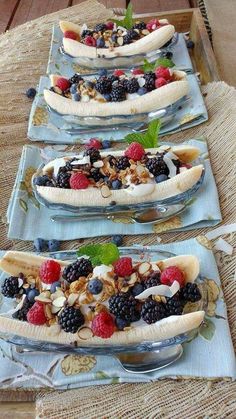 three plates with bananas, berries and nuts on them