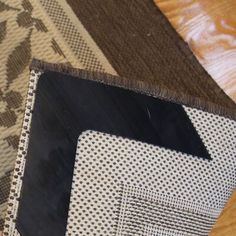 a close up of a piece of cloth on a wooden floor with an arrow pointing to the left