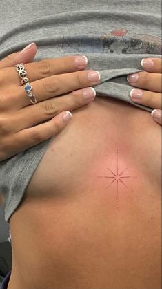 a woman's stomach with a small star tattoo on it