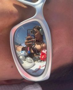 a woman taking a selfie in the reflection of her sunglasses