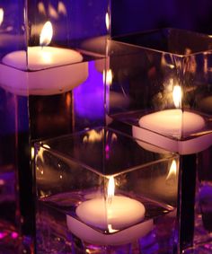 candles are lit in glass cubes on a table
