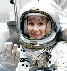 a woman in an astronaut suit is smiling for the camera